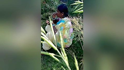 Amateur brunette girl playing with a peacock outdoors
