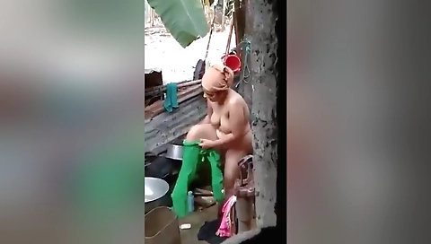 Indian brunette in a bikini is in the sun and getting wet