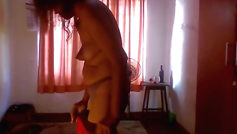 Indian maid is dressing herself and wearing black dress